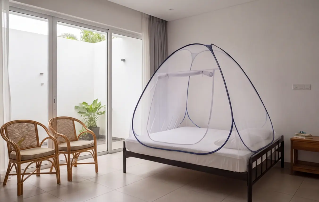 A white Hero pop-up dome mosquito net standing on a double bed in a bright room